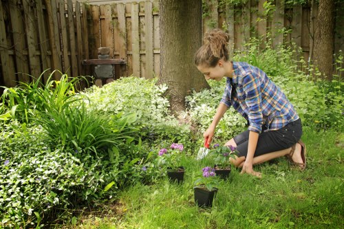 Trainer demonstrating safe hedge-cutting techniques to staff